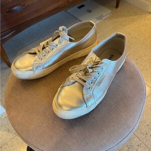 Superga silver tennis shoes. Also known as sneakers or trainers.